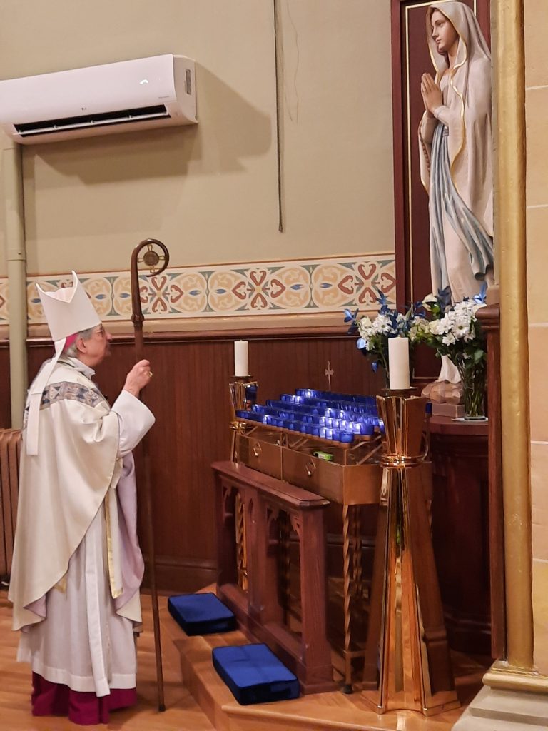 Bishop prays in front of the Blessed Mother Shrine